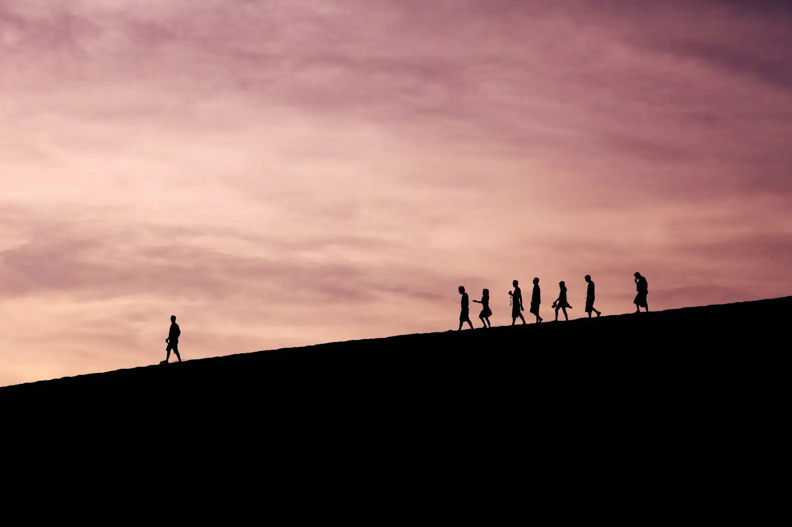 Gruppe von Personen als Silhouetten auf einem Hügelkamm